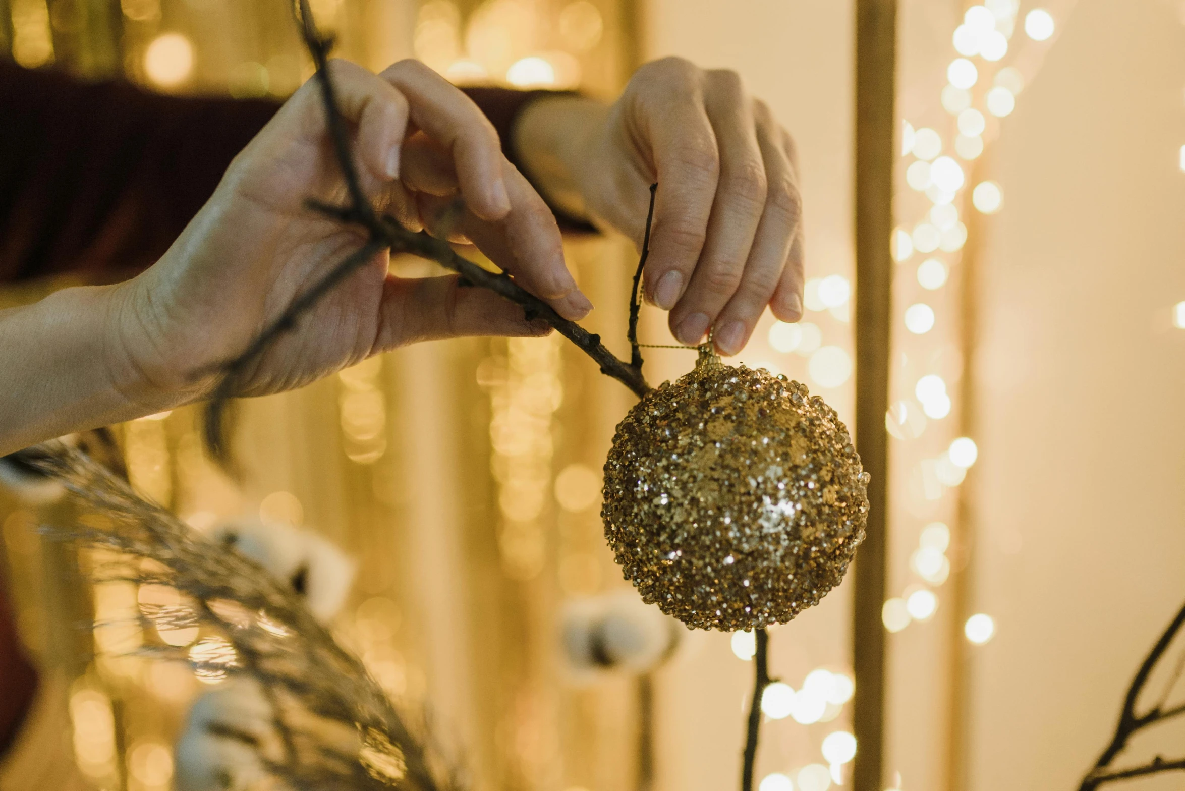 a close up of a person holding an ornament, pexels contest winner, arts and crafts movement, gold dappled lighting, string lights, thumbnail