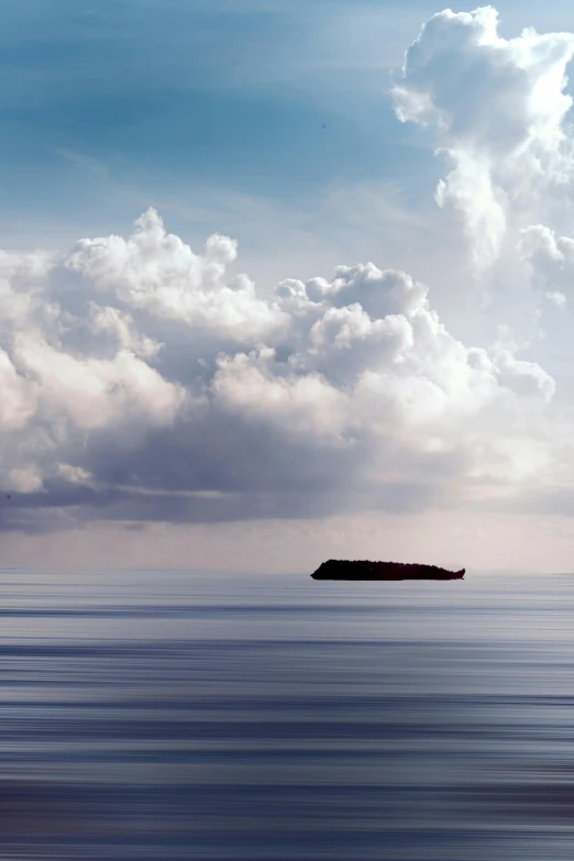 a small island in the middle of a large body of water, inspired by Michal Karcz, unsplash, minimalism, container ship, clouds visible, mediterranean, indonesia