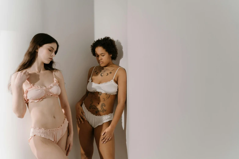 a couple of women standing next to each other, trending on pexels, rococo, white bra, pale, collection, pale pink bikini