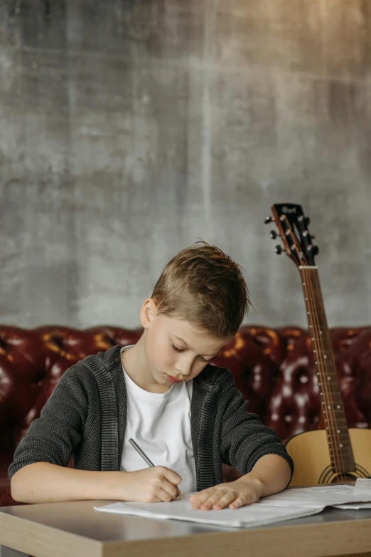 a young boy sitting at a table with a guitar, trending on pexels, studious, textured, confident looking, thumbnail