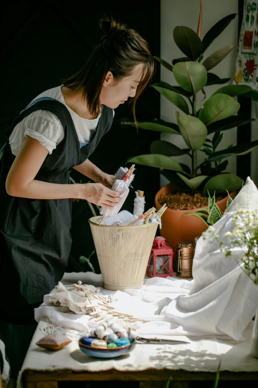 a woman that is standing in front of a table, gardening, linen, profile image, maid outfit