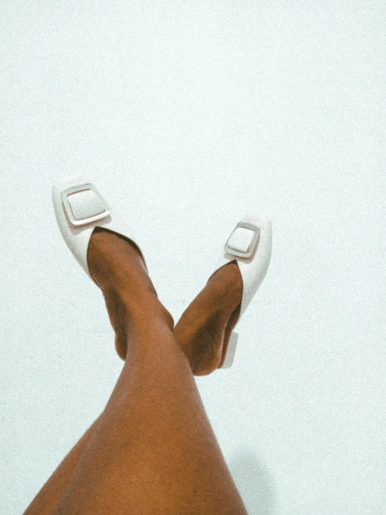 a close up of a person's legs wearing white shoes, by Olivia Peguero, square, slippers, patent style, 8 k )