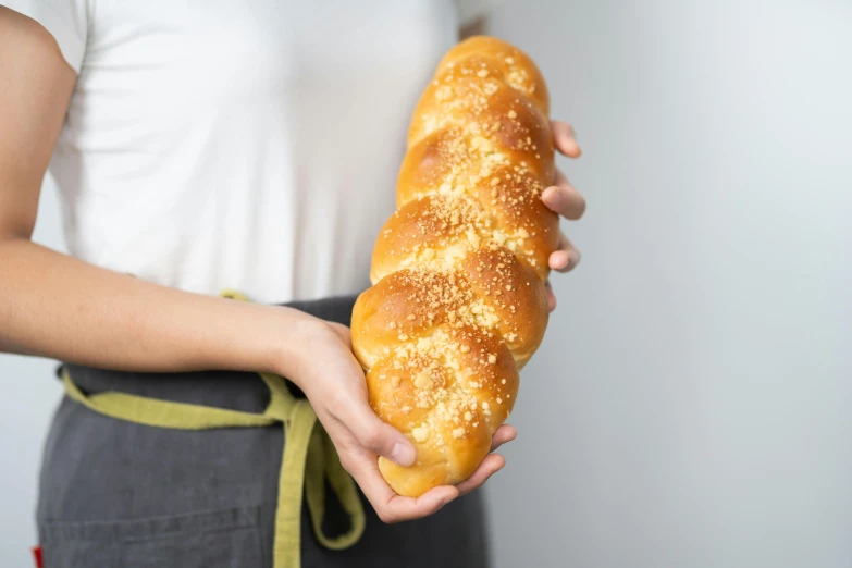 a woman holding a loaf of bread in her hands, by Niko Henrichon, unsplash, hyperrealism, 8ft tall, twisted braid, voluptuous sesame seed bun, 3/4 front view