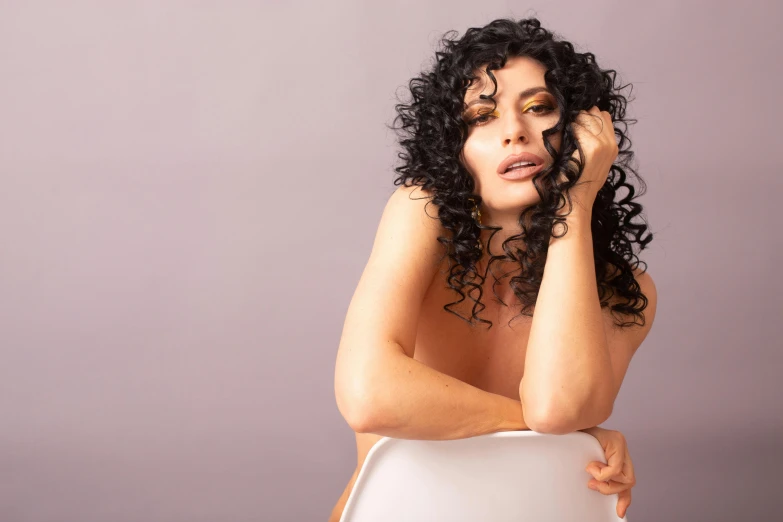 a woman sitting on top of a white chair, an album cover, inspired by Bert Stern, trending on pexels, hyperrealism, curly black hair, portait of haifa wehbe, pastel', sexy :8