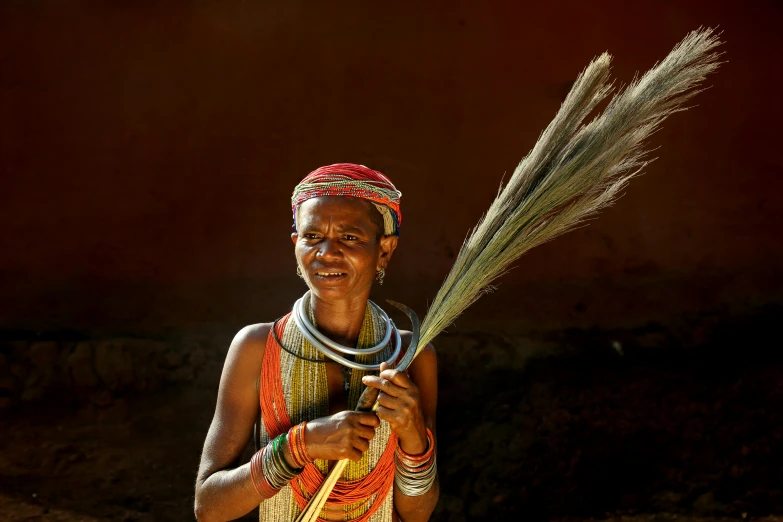 a close up of a person holding a broom, a portrait, by Dietmar Damerau, pexels contest winner, hurufiyya, madagascar, slide show, portrait image