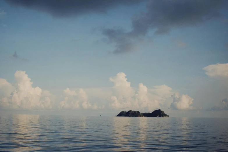 a small island in the middle of the ocean, by Carey Morris, unsplash, sumatraism, john pawson, calm clouds, ignant, taken in the late 2010s