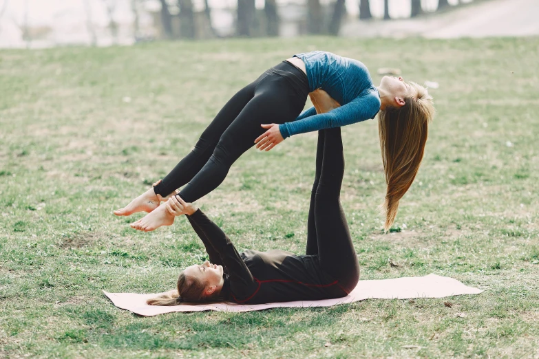 a man and a woman doing yoga in a park, a picture, unsplash, arabesque, woman holding another woman, 9 9 designs, lesbians, which splits in half into wings