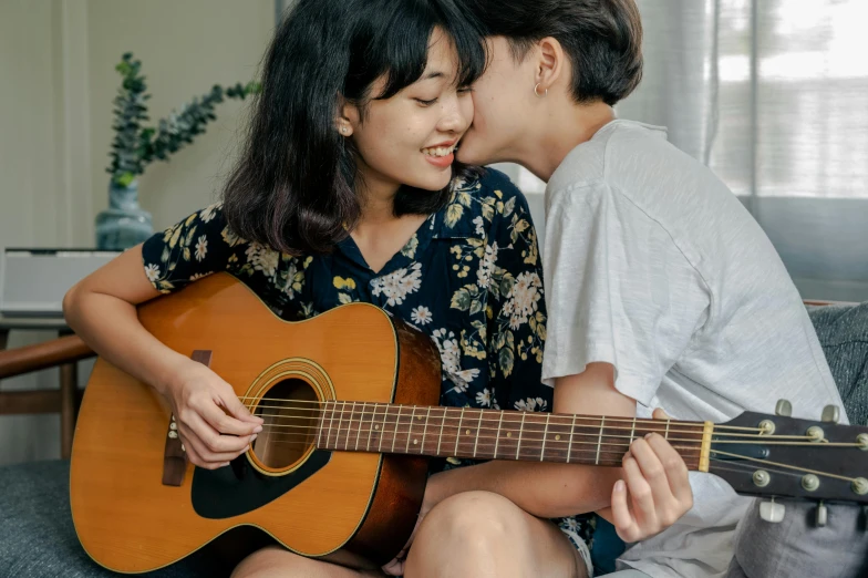 a man and a woman sitting on a couch with a guitar, trending on pexels, sōsaku hanga, peasant boy and girl first kiss, asian women, profile image
