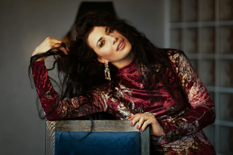 a woman sitting on top of a blue chair, an album cover, pexels contest winner, arabesque, shohreh aghdashloo, dressed in velvet, julia gorokhova, portrait image