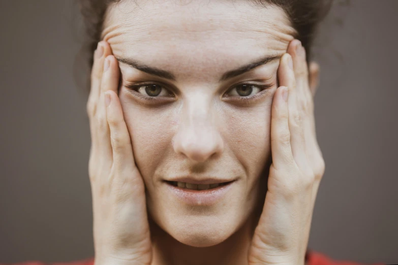 a woman holding her hands to her face, by Nina Hamnett, trending on pexels, renaissance, square facial structure, nerves, tinnitus, machine parts embedded into face