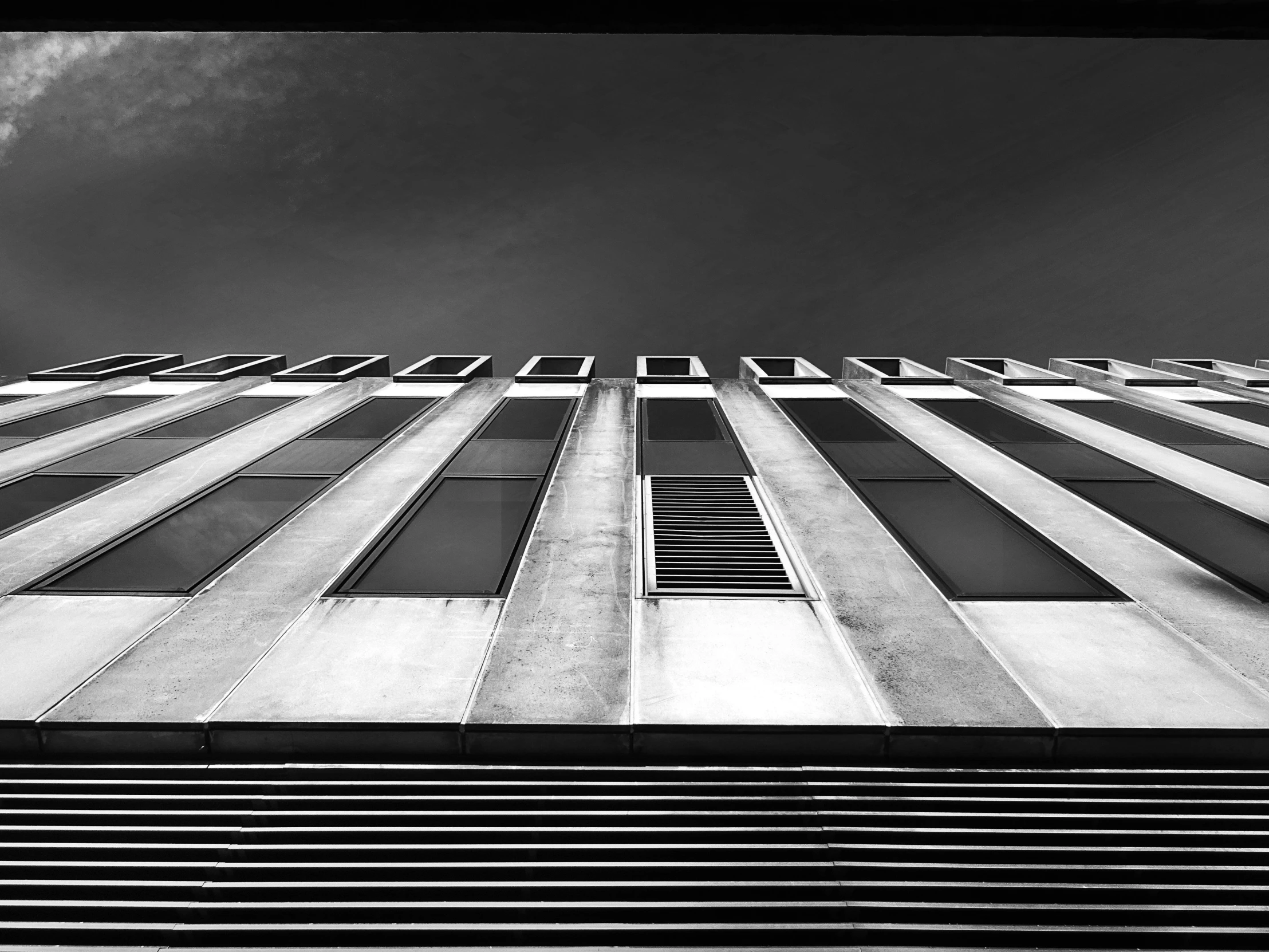 a black and white photo of a tall building, unsplash, brutalism, square lines, photographic print, view from ground level, fine art print