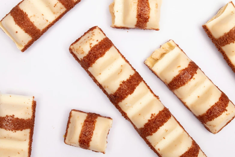 a group of desserts sitting on top of a white surface, streamlined spines, cheddar, thumbnail, square lines