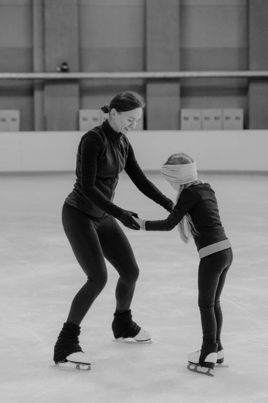 a woman teaching a young girl how to skate, a black and white photo, by Tom Bonson, pexels contest winner, arabesque, made of ice, indoor picture, various posed, foto