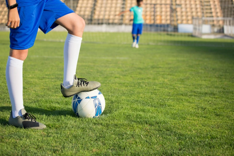 a person kicking a soccer ball on a field, children's, profile image, fan favorite, knee pads