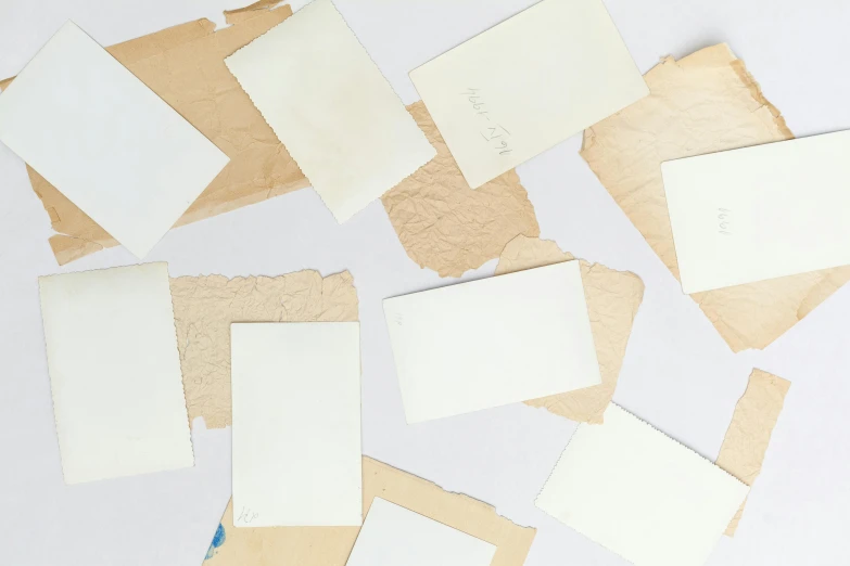 a bunch of pieces of paper sitting on top of a table, inspired by Rachel Whiteread, trending on unsplash, mail art, paper texture 1 9 5 6, background image, playing cards, with a white background