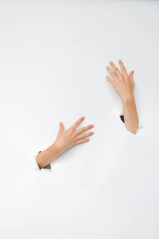 two hands reaching out of a hole in a sheet of paper, an album cover, inspired by Cornelia Parker, trending on pexels, conceptual art, ron mueck, white backdrop, 15081959 21121991 01012000 4k, ( ultra realistic