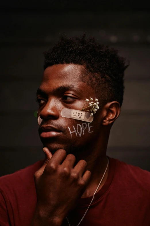 a man with a piece of tape on his face, an album cover, by Lily Delissa Joseph, trending on pexels, hyperrealism, kevin hart, sense of hope, promotional picture, hope