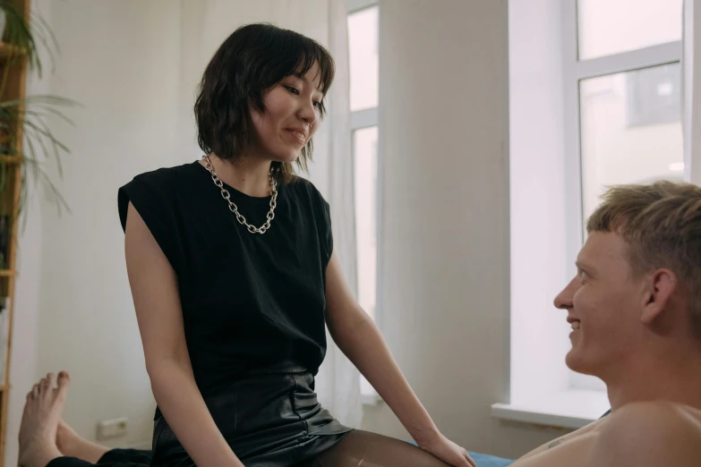 a woman sitting on top of a bed next to a man, a portrait, by Emma Andijewska, unsplash, massurrealism, low quality footage, smiling at each other, put on a mannequin, brunette