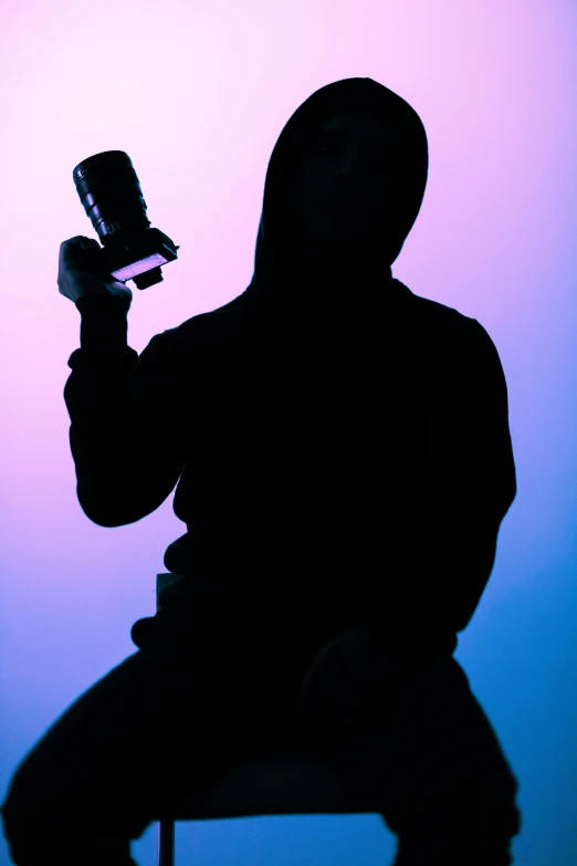 a person sitting on a chair holding a cell phone, pexels, graffiti, a hooded killer a cane, purple light, holding wine bottle, silhouette :7