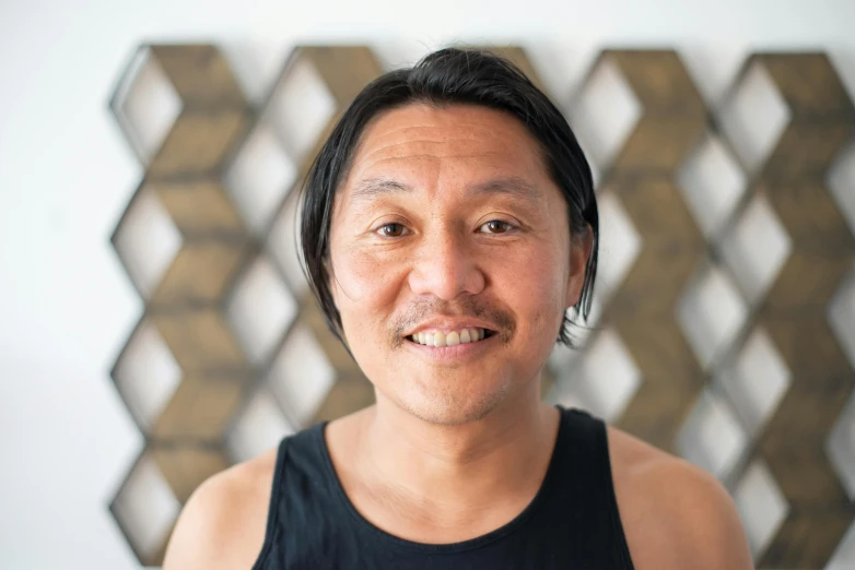 a close up of a person wearing a tank top, a character portrait, unsplash, shin hanga, marc newson, south east asian with round face, inuit, slightly smiling