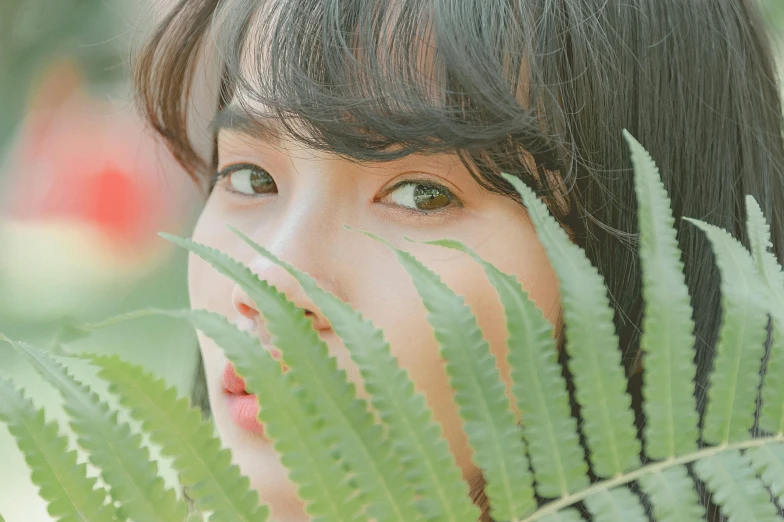 a close up of a person holding a plant, a picture, inspired by Kim Jeong-hui, trending on pexels, young adorable korean face, exotic eyes, fluffy bangs, stylized photo