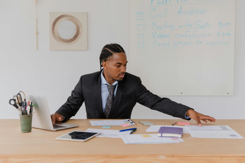 a man sitting at a desk in front of a laptop computer, pexels contest winner, whiteboards, a black man with long curly hair, lawyer clothing, 1 2 9 7