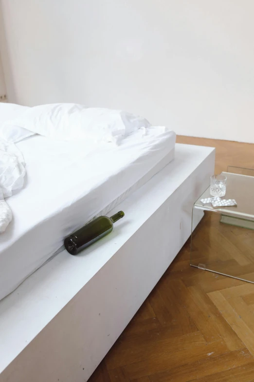 a white bed sitting on top of a wooden floor, an album cover, inspired by Sarah Lucas, arte povera, wine bottle, tokujin yoshioka, detail, cast glass