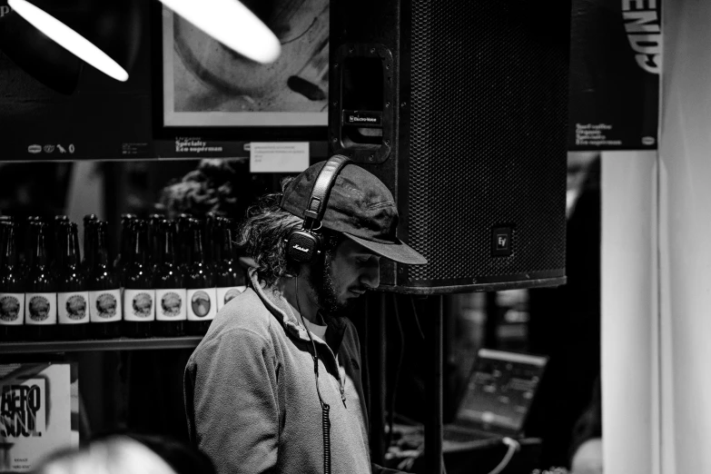 a man standing in front of a speaker in a store, pexels, process art, with head phones, concert photo, profile picture 1024px, taken in the early 2020s