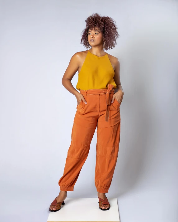 a woman in an orange top and orange pants, thumbnail, display”