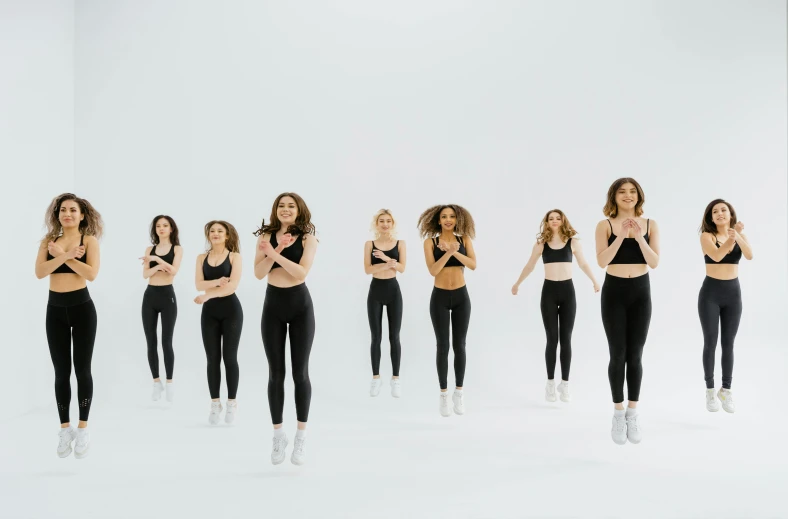 a group of women standing in front of a white wall, trending on pexels, antipodeans, running sequence, 6 pack ab, sprites, sculpted