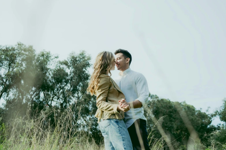 a man and woman standing in a field of tall grass, a picture, unsplash, happening, sydney park, background image, making out, attractive photo