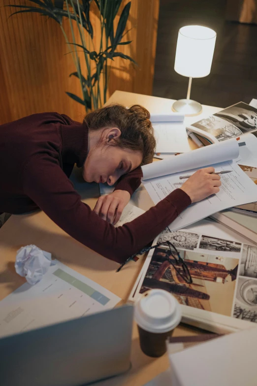 a woman that is laying down on a desk, by Nina Hamnett, pexels contest winner, two exhausted, charts, ignant, college