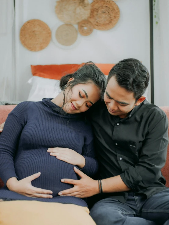 a man and a woman sitting on a couch, pexels contest winner, maternity feeling, profile image, asian male, orange fluffy belly