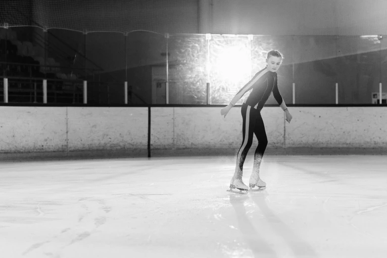 a black and white photo of a person on a skateboard, made of ice, standing in an arena, indoor smooth light, carole feuerman