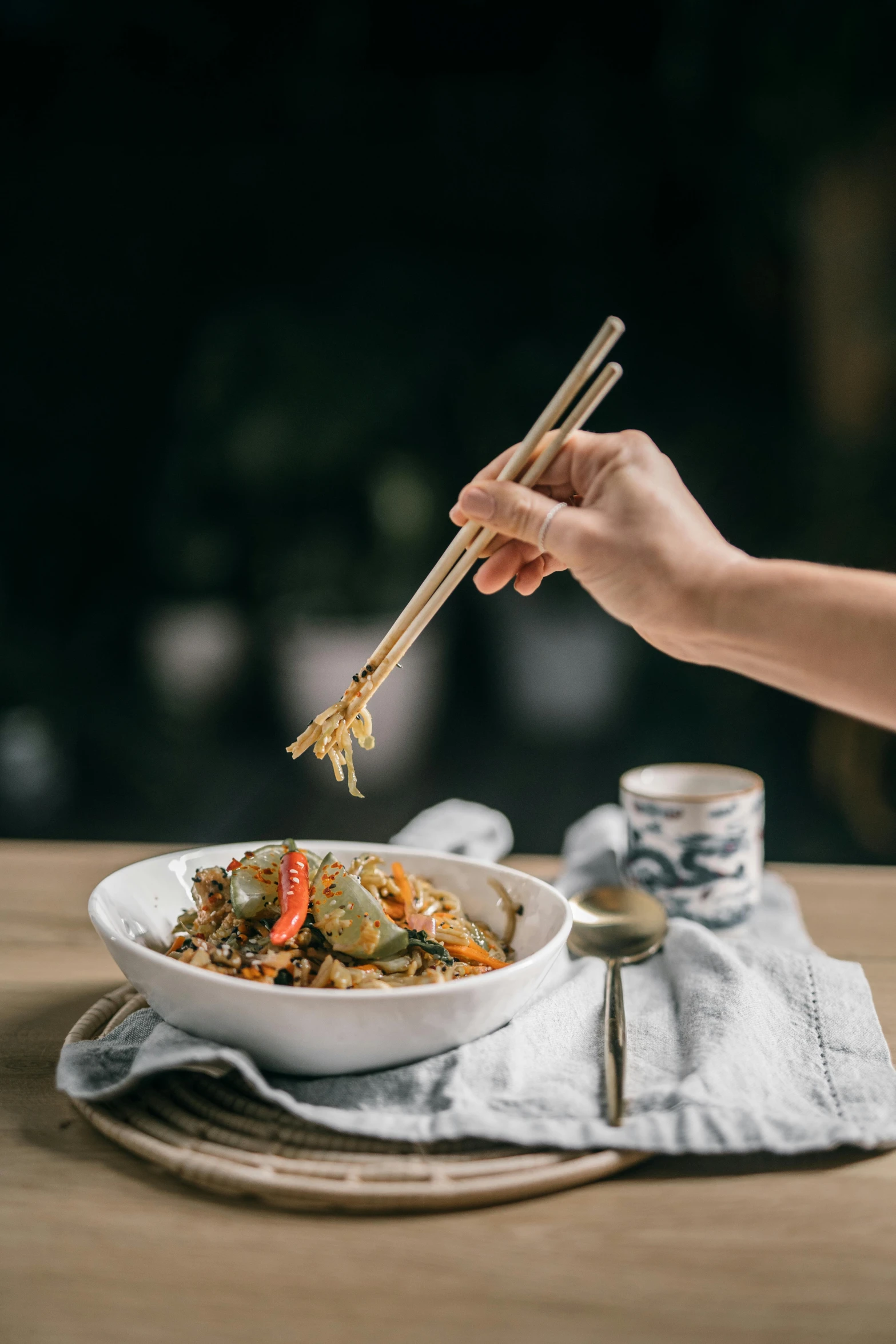 a person holding chopsticks over a bowl of food, square, grey, banner, 4l