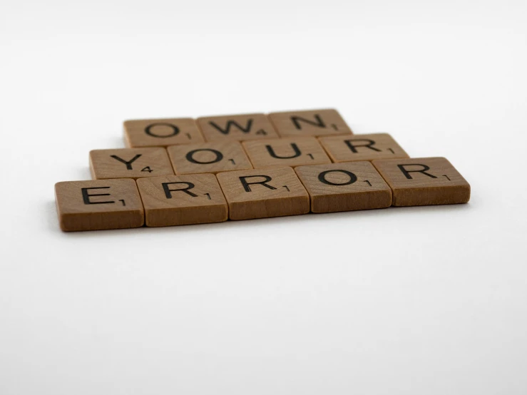 a scrabble that says own your error, an album cover, pexels, dezeen, no words 4 k, crypto, brown