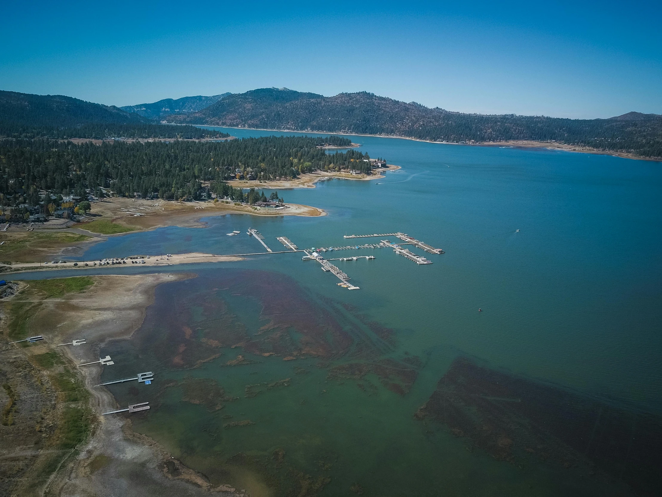 a large body of water next to a forest, by Arnie Swekel, pexels contest winner, land art, big bear lake california, with water and boats, aerial footage, thumbnail