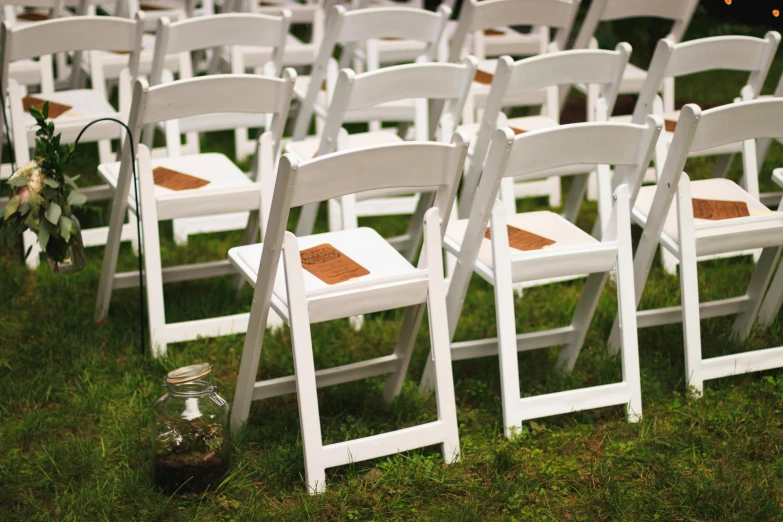 a row of white chairs sitting on top of a lush green field, pexels, renaissance, unholy ceremony, brown, beaten, lynn skordal