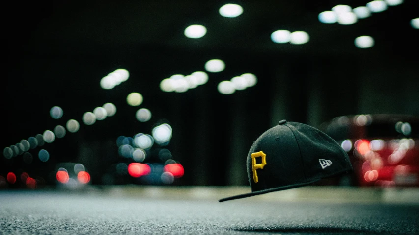 a baseball cap sitting on top of a parking lot, inspired by Paul Lohse, unsplash contest winner, pirates, pikachu, with professional lighting, smooth in _ the background