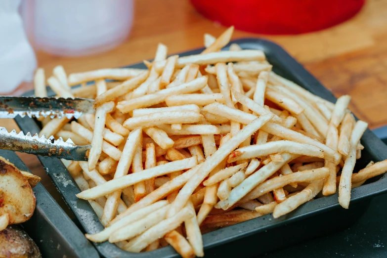 a tray of french fries sitting on top of a table, unsplash, square lines, melbourne, fan favorite, frying nails