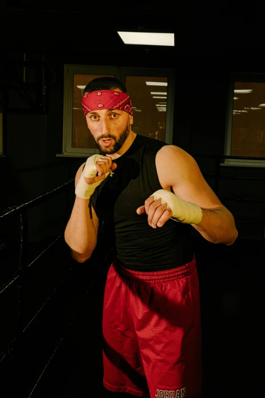 a man in a black shirt and red shorts, inspired by Volkan Baga, featured on reddit, golden gloves, production photo, turban, promo image