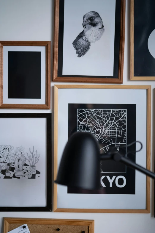 a lamp sitting on top of a desk next to pictures, poster art, inspired by Eero Snellman, trending on unsplash, lyco art, white on black, map, inside a frame on a tiled wall, studio kyoto
