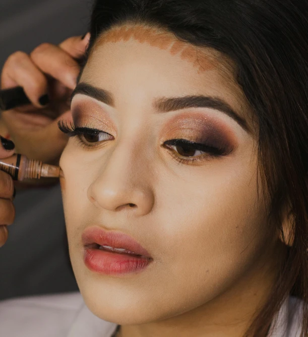 a woman is getting her make up done, trending on pexels, realism, peruvian looking, sharp nose with rounded edges, frontal pose, traditional makeup