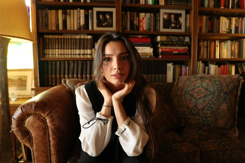 a woman sitting in a chair in front of a bookshelf, a portrait, reddit, hurufiyya, portrait emily ratajkowski, 15081959 21121991 01012000 4k, arab young monica belluci, anya taylor joy