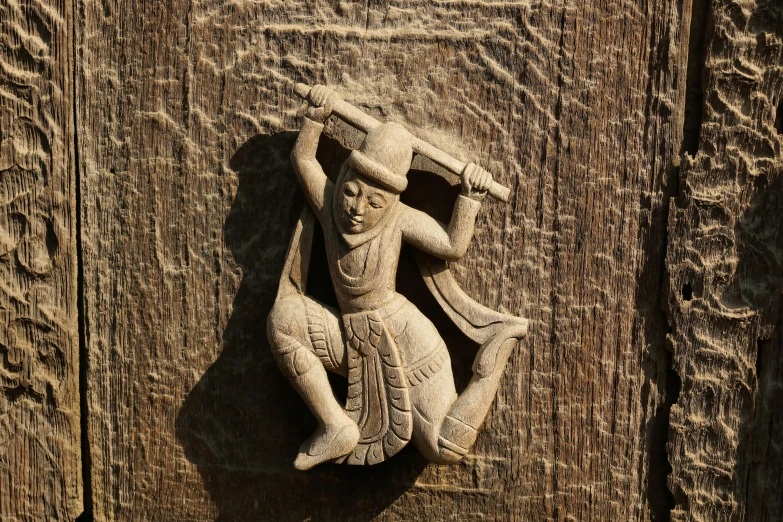 a close up of a statue on a wooden door, inspired by Li Di, folk art, dancing a jig, getty images, naranbaatar ganbold, made from old stone