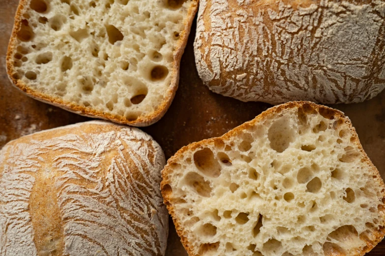 a bunch of bread sitting on top of a wooden table, detailed product image, limestone, slide show, fibbonacci