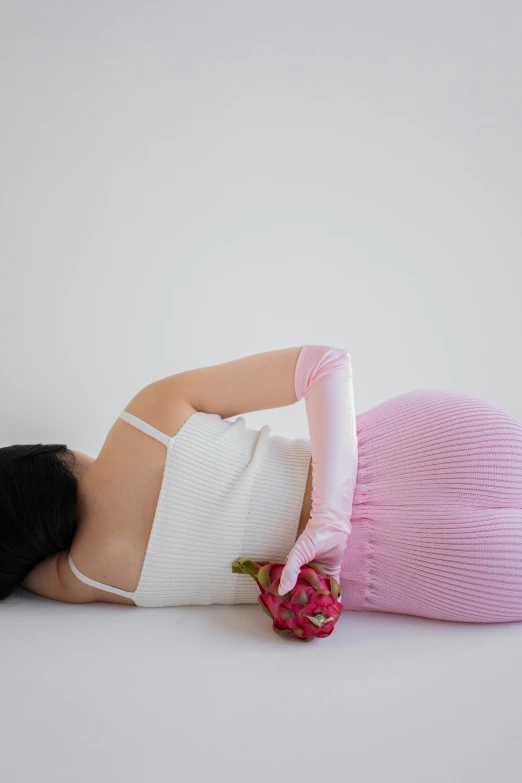 a woman laying on her stomach with a flower in her hand, inspired by Sarah Lucas, reddit, white and light-pink outfit, a pair of ribbed, covered with pink marzipan, bum