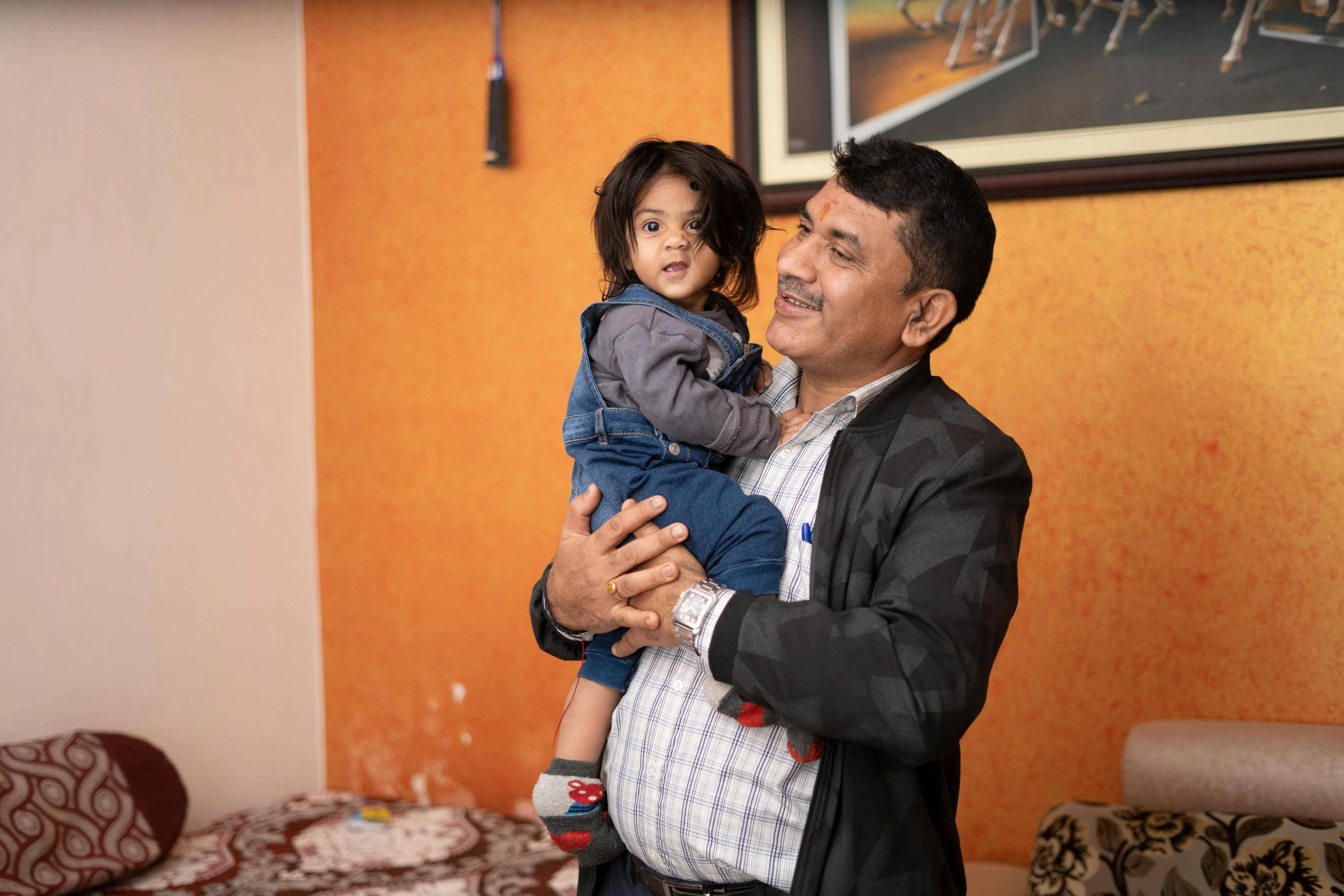 a man holding a small child in his arms, pexels, hurufiyya, avatar image, full body photograph, at home, colour photograph