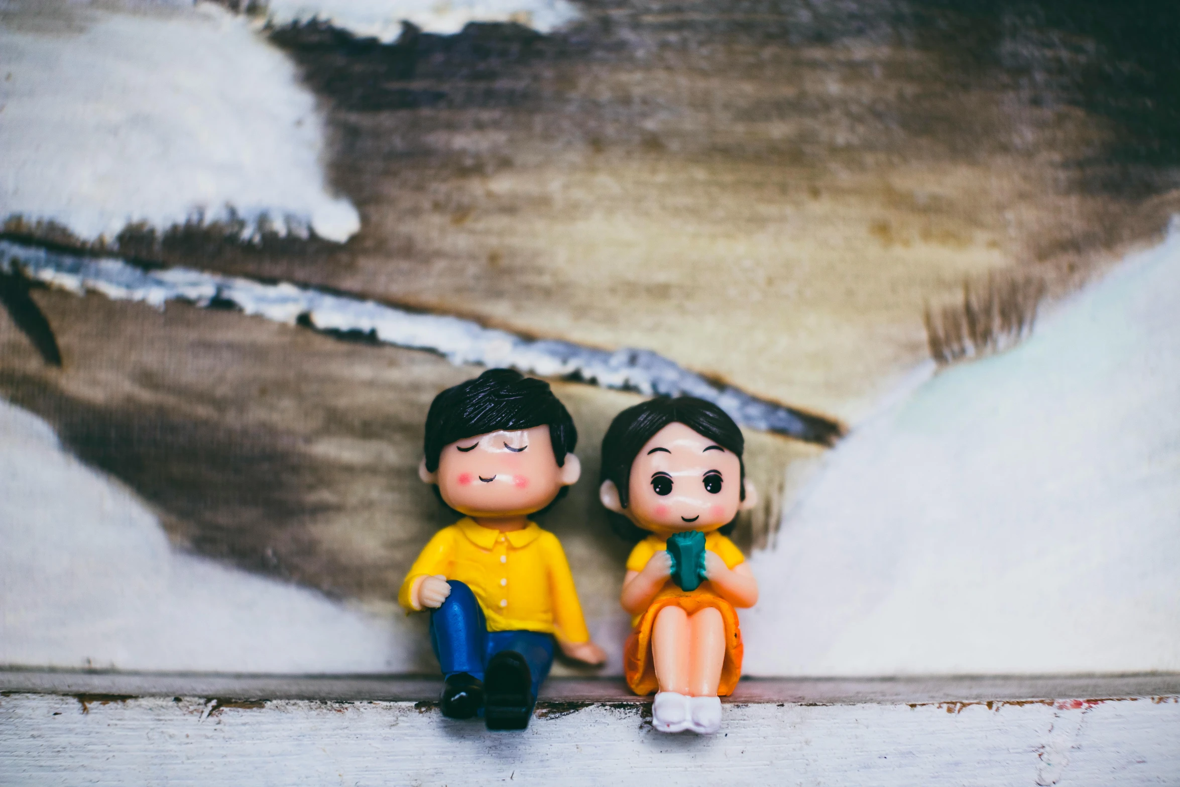 a couple of figurines sitting next to each other, a cartoon, inspired by Nara Yoshitomo, pexels, kodak portra film, winter setting, cute colorful adorable, on a canva