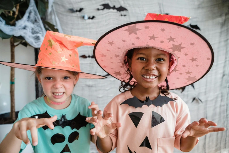 a couple of young girls standing next to each other, pexels, witch hat, avatar image, children playing with pogs, bats